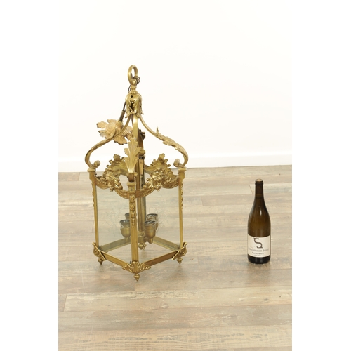 632 - A LATE 19TH CENTURY GILT BRASS SQUARE HANGING LANTERN with acanthus leaf shaped arms above masked ri... 