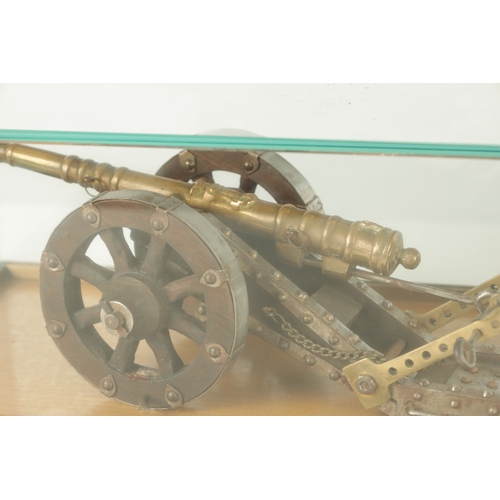 650 - TWO 20TH CENTURY BRONZE MODEL CANNON on wooden carriages - in glass display cabinets (32cm wide )