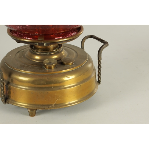 657 - A LATE 19TH CENTURY BRASS HEARTH LAMP the shallow two-handled container base on three small feet sup... 