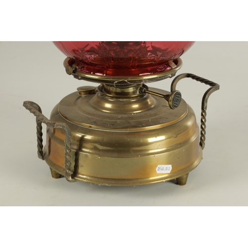 657 - A LATE 19TH CENTURY BRASS HEARTH LAMP the shallow two-handled container base on three small feet sup... 