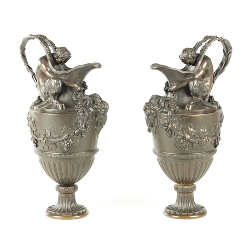 661 - A PAIR OF LATE 19TH CENTURY BRONZE EWERS OF CLASSICAL FORM with Baccus seated on the shoulder with r... 