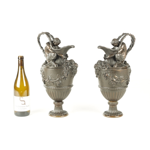 661 - A PAIR OF LATE 19TH CENTURY BRONZE EWERS OF CLASSICAL FORM with Baccus seated on the shoulder with r... 