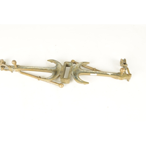 663 - A LATE 19TH CENTURY BRASS HANGING BRACKET with anchors and a pulley to each end. (58cm wide)