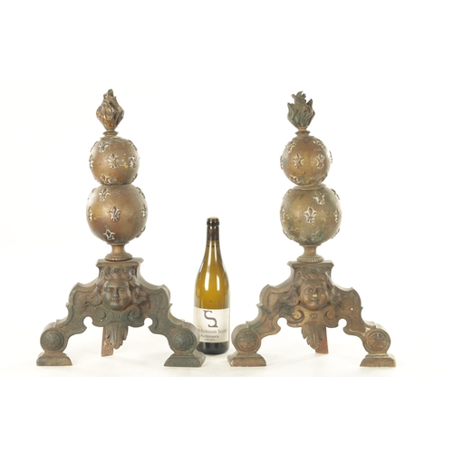 668 - A PAIR OF 19TH CENTURY BRASS FIRE DOGS with torch finials above bulbous stems and mask head shaped b... 