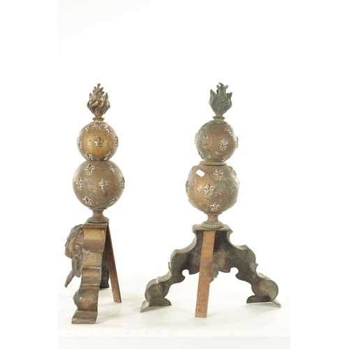 668 - A PAIR OF 19TH CENTURY BRASS FIRE DOGS with torch finials above bulbous stems and mask head shaped b... 