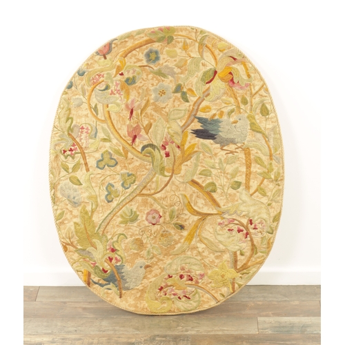 673 - AN 18TH CENTURY EMBROIDERED OVAL PANEL having birds within flowering trees (99cm high 81cm wide )