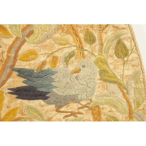 673 - AN 18TH CENTURY EMBROIDERED OVAL PANEL having birds within flowering trees (99cm high 81cm wide )