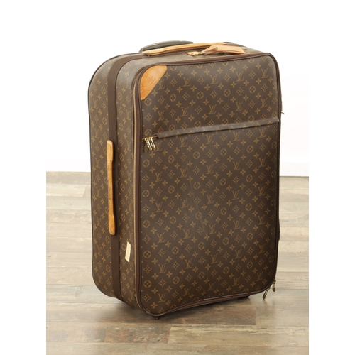 676 - A GENUINE LOUIS VUITTON SUITCASE with monogrammed decoration and brown leather carrying handle. (68c... 