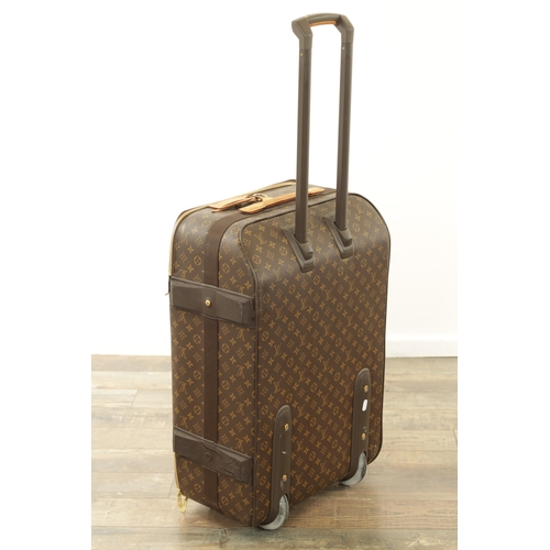 676 - A GENUINE LOUIS VUITTON SUITCASE with monogrammed decoration and brown leather carrying handle. (68c... 