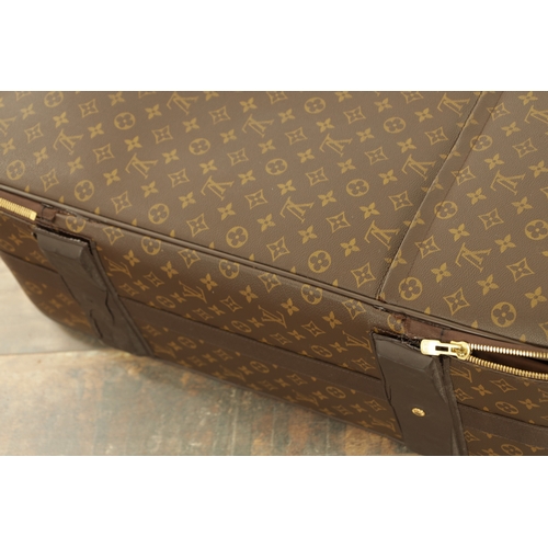 676 - A GENUINE LOUIS VUITTON SUITCASE with monogrammed decoration and brown leather carrying handle. (68c... 