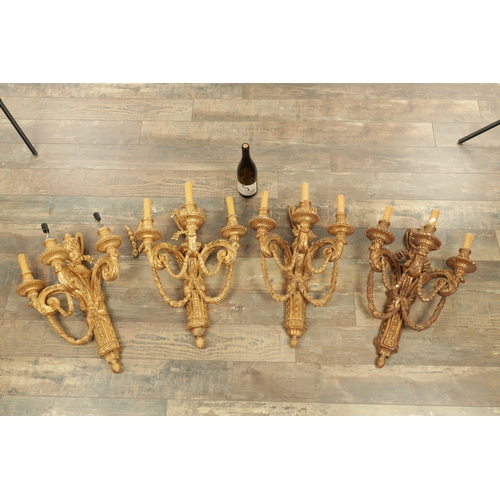 696 - A SET OF FOUR CARVED GILTWOOD ADAM STYLE HANGING WALL LIGHTS with urn-shaped leaf-carved bodies havi... 