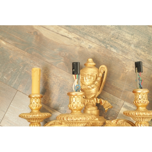 696 - A SET OF FOUR CARVED GILTWOOD ADAM STYLE HANGING WALL LIGHTS with urn-shaped leaf-carved bodies havi... 