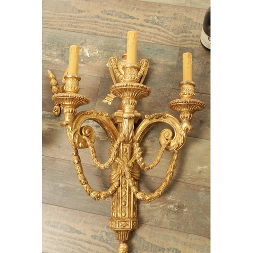 696 - A SET OF FOUR CARVED GILTWOOD ADAM STYLE HANGING WALL LIGHTS with urn-shaped leaf-carved bodies havi... 