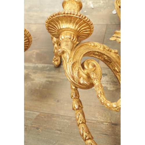 696 - A SET OF FOUR CARVED GILTWOOD ADAM STYLE HANGING WALL LIGHTS with urn-shaped leaf-carved bodies havi... 