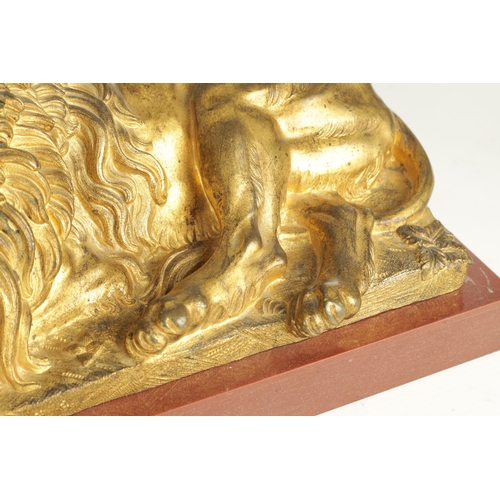 698 - A PAIR OF LATE 19TH CENTURY GILT BRONZE RECUMBENT LIONS mounted on marble plinths (30.5cm wide 16.5c... 