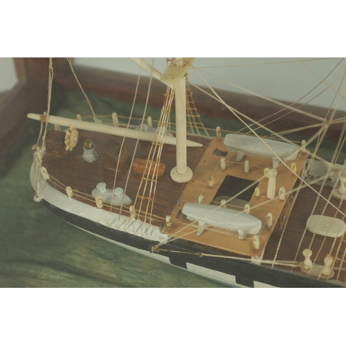 703 - A 19TH CENTURY SAILOR MADE CASED MODEL OF A FOUR MASTED SCHOONER SHIP, with bone masts and painted w... 