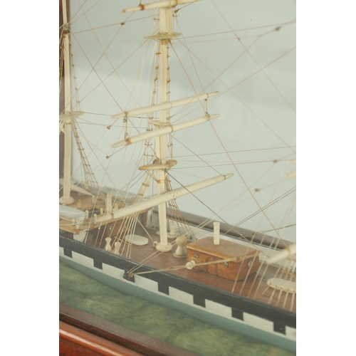 703 - A 19TH CENTURY SAILOR MADE CASED MODEL OF A FOUR MASTED SCHOONER SHIP, with bone masts and painted w... 