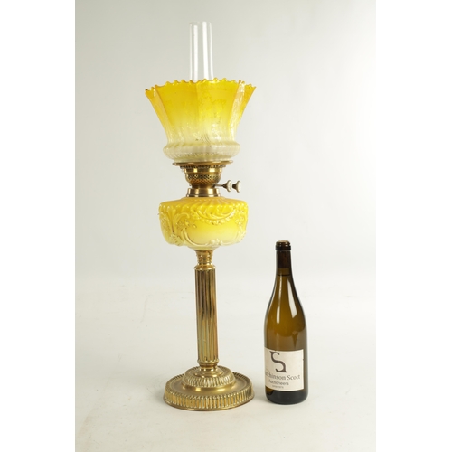 713 - A FINE VICTORIAN BRASS AND YELLOW GLASS OIL LAMP the stepped circular gadroon-edged base with reeded... 