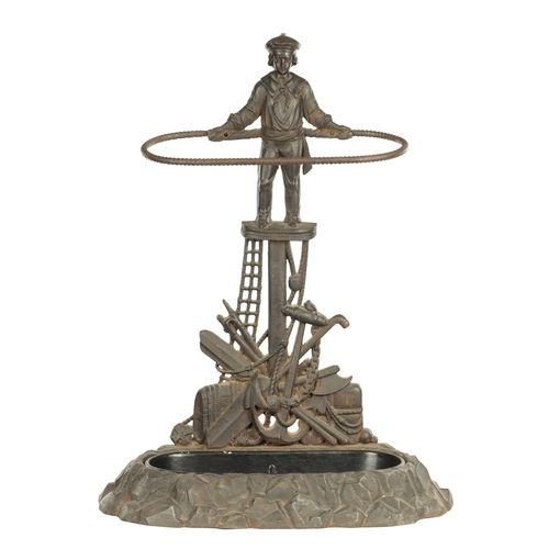 714 - A LATE 19TH CENTURY CAST IRON STICK STAND modelled as a sailor standing over an anchor and flags wit... 