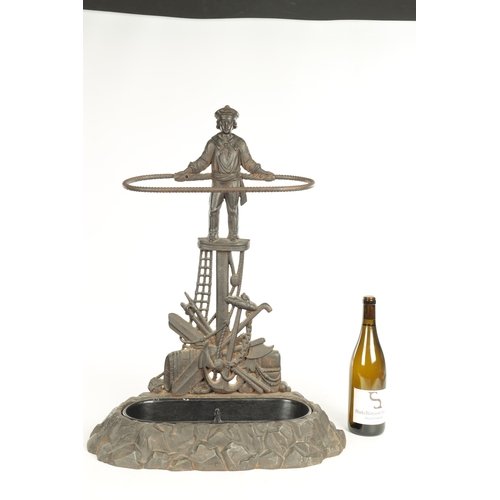 714 - A LATE 19TH CENTURY CAST IRON STICK STAND modelled as a sailor standing over an anchor and flags wit... 