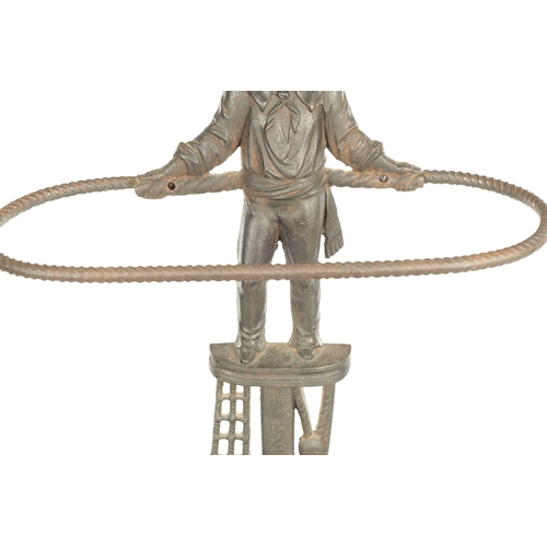 714 - A LATE 19TH CENTURY CAST IRON STICK STAND modelled as a sailor standing over an anchor and flags wit... 