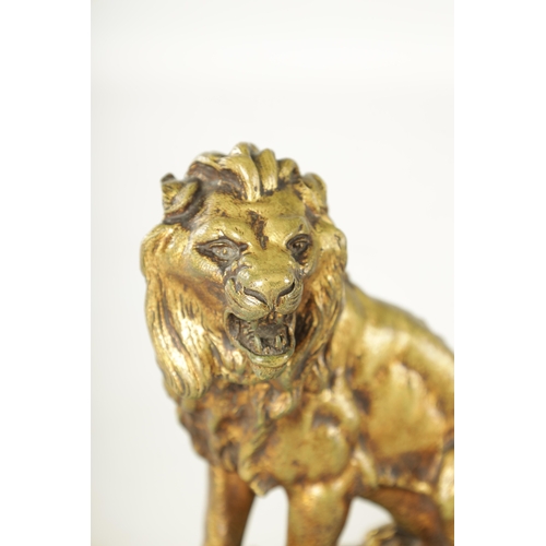 720 - A PAIR OF EARLY 20TH CENTURY GILT BRONZE SCULPTURES depicting a Lion and Lioness on naturalistic mar... 