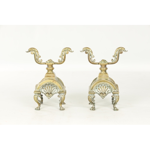 729 - A PAIR OF LATE 19TH CENTURY BRASS FIRE DOGS with arched shell bodies raised on lions paw feet (23cm ... 