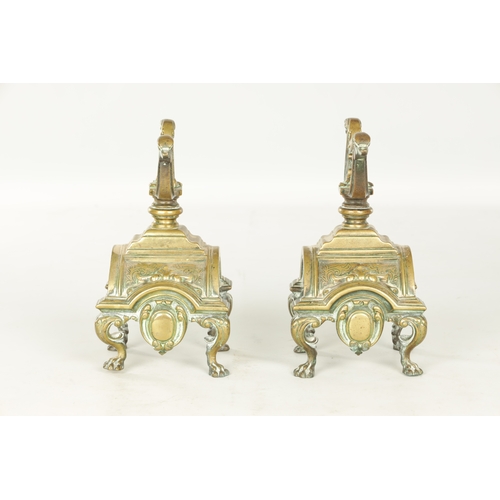 729 - A PAIR OF LATE 19TH CENTURY BRASS FIRE DOGS with arched shell bodies raised on lions paw feet (23cm ... 