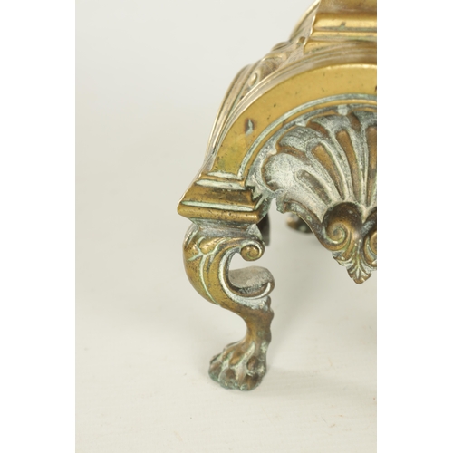 729 - A PAIR OF LATE 19TH CENTURY BRASS FIRE DOGS with arched shell bodies raised on lions paw feet (23cm ... 