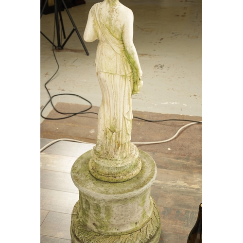 752 - A CARVED WHITE LIMESTONE OF A MAIDEN in classical dress mounted on a circular plinth base.