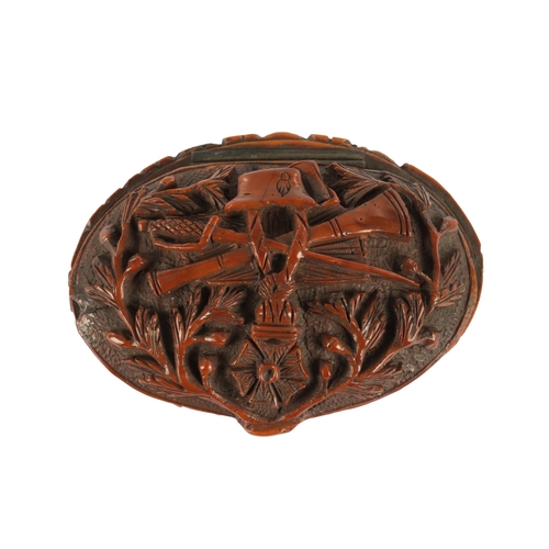 755 - A 19TH CENTURY CARVED COQUILLA NUT SNUFF BOX decorated with a military crest and leaf work border. (... 