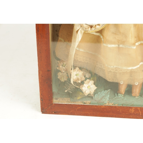 757 - A 19TH CENTURY WAX OVER DOLL FIGURE IN A GLAZED DISPLAY CABINET in full dress with floral decoration... 