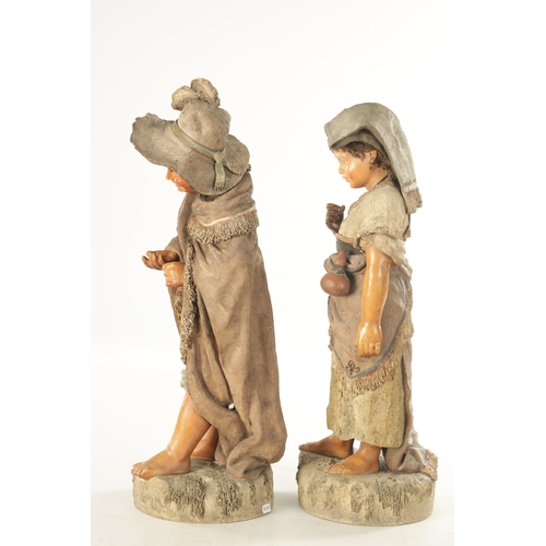 765 - A LARGE PAIR OF 19TH CENTURY POLYCHROME TERRACOTTA FIGURES modelled as a young boy and girl on natur... 