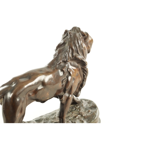 785 - A 19TH CENTURY BROWN PATINATED STANDING BRONZE LION on a naturalistic, earthy base and plain moulded... 