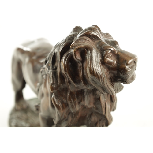 785 - A 19TH CENTURY BROWN PATINATED STANDING BRONZE LION on a naturalistic, earthy base and plain moulded... 