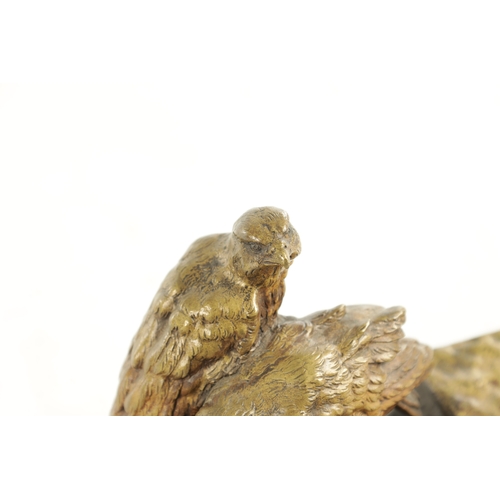 797 - AN EARLY 20TH CENTURY GILT BRONZE PEN AND INK STAND depicting a perched pair of birds of prey on a r... 