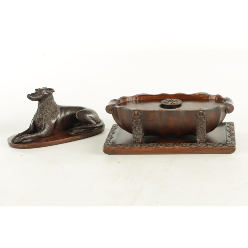 890 - A RARE 19TH CENTURY CARVED WALNUT BLACK FOREST INKWELL formed as a recumbent greyhound raised on a s... 