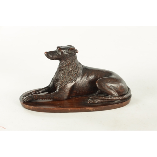 890 - A RARE 19TH CENTURY CARVED WALNUT BLACK FOREST INKWELL formed as a recumbent greyhound raised on a s... 