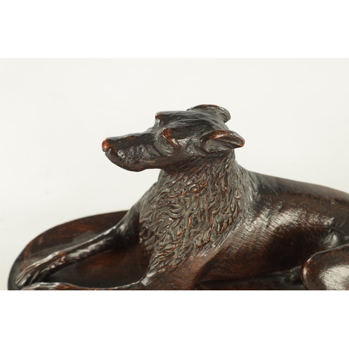 890 - A RARE 19TH CENTURY CARVED WALNUT BLACK FOREST INKWELL formed as a recumbent greyhound raised on a s... 