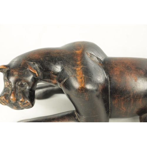 894 - A 19TH/EARLY 20TH CENTURY CARVED STAINED HARDWOOD SCULPTURE OF A RECUMBENT BIG CAT (31cm length)