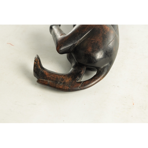 894 - A 19TH/EARLY 20TH CENTURY CARVED STAINED HARDWOOD SCULPTURE OF A RECUMBENT BIG CAT (31cm length)