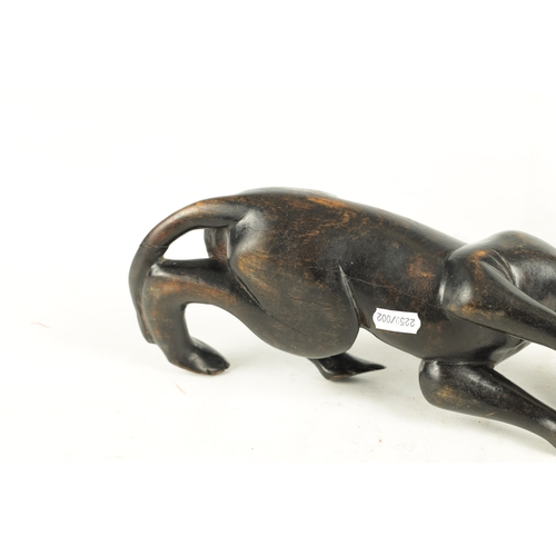 894 - A 19TH/EARLY 20TH CENTURY CARVED STAINED HARDWOOD SCULPTURE OF A RECUMBENT BIG CAT (31cm length)