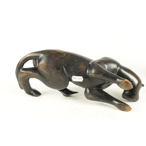 894 - A 19TH/EARLY 20TH CENTURY CARVED STAINED HARDWOOD SCULPTURE OF A RECUMBENT BIG CAT (31cm length)