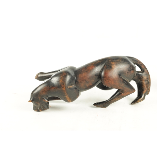 894 - A 19TH/EARLY 20TH CENTURY CARVED STAINED HARDWOOD SCULPTURE OF A RECUMBENT BIG CAT (31cm length)