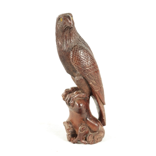 897 - A LATE 19TH CENTURY CARVED SCULPTURE OF AN EAGLE with glass eyes, standing on a naturalistic base. (... 