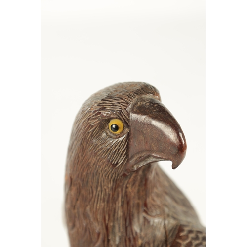 897 - A LATE 19TH CENTURY CARVED SCULPTURE OF AN EAGLE with glass eyes, standing on a naturalistic base. (... 