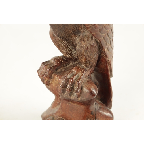 897 - A LATE 19TH CENTURY CARVED SCULPTURE OF AN EAGLE with glass eyes, standing on a naturalistic base. (... 