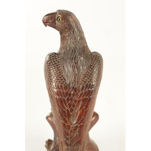 897 - A LATE 19TH CENTURY CARVED SCULPTURE OF AN EAGLE with glass eyes, standing on a naturalistic base. (... 