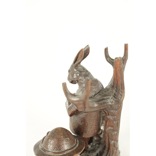 900 - A GOOD 19TH CENTURY BLACK FOREST CARVED LINDEN WOOD INKSTAND formed as a standing hare with branchwo... 