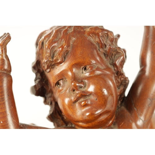 908 - A 19TH CENTURY ITALIAN CARVED WALNUT SCULPTURE of a winged cherub (37cm high 28cm wide )